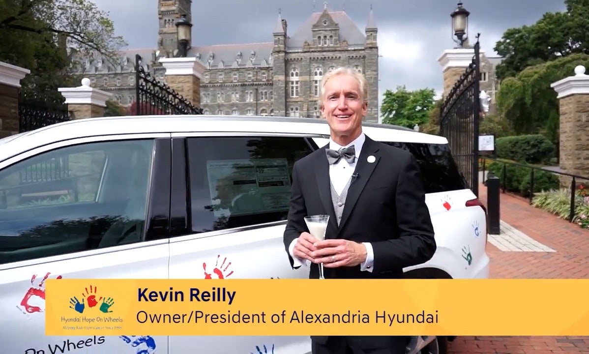 Kevin Reilly in a tuxedo with a champagne flute of Milk at the Healy Gates
